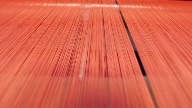 Plenty of red threads while being woven from
