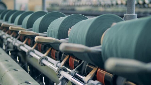 Reels with threads are spinning on the sewing mechanisms