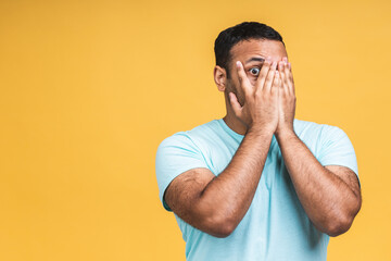 Surprised amazed african american indian man guy in casual isolated over yellow background studio portrait. People lifestyle concept. Mock up copy space. Keeping mouth open.