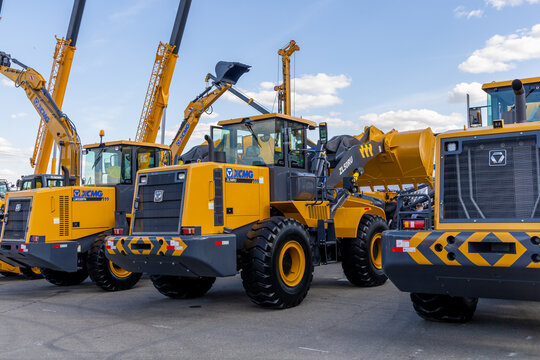 The stand of the XCMG company at the construction fair Bauma CTT Russia. Front wheel loaders LW330FN and ZL50RU, excavators and cranes at the open exhibition area. Moscow, Russia - May 25-28, 2021
