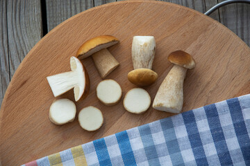 Mushrooms cut with a knife lie on a cutting board. Edible porcini mushrooms. View from above.