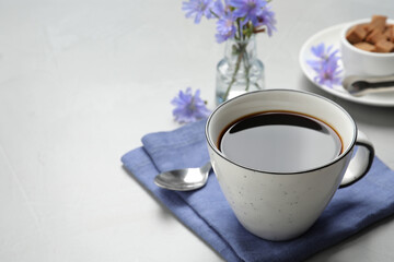 Cup of delicious chicory drink on light grey table, space for text