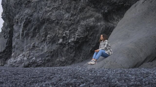 Landscape View of a Female Sitting on the Side of the Gardar Basalt Columns