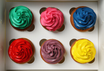Different cupcakes with cream in box, closeup