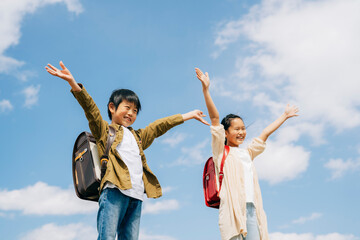 バンザイする元気な小学生
