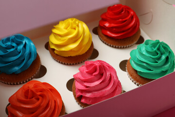 Different cupcakes with cream in box, closeup
