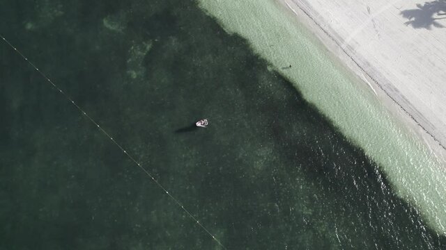 Unos ni&ntilde;os est&aacute;n aprendiendo a manejar un optimist en un mar en calma del caribe mexicano