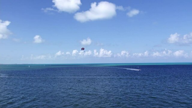Un paraca&iacute;das es arrastrado por una lancha en un mar en calma