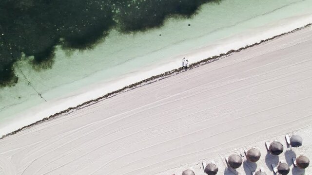 Una pareja est&aacute; caminando junta en una playa paradis&iacute;aca del caribe mexicano