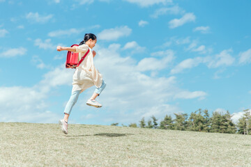 公園で走る小学生の女の子（ジャンプ）
