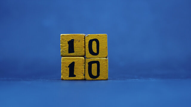 Wooden block calendar showing the 10th month of the 10th. Isolated on a blue background