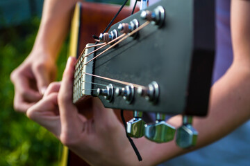 A young guy plays guitar, music in the fresh air.