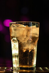 Iced cocktail in a glass at a nightclub. Colorful footage in a nightclub. Alcoholic drink of different colors. Nightlife scene. Shots at the bar table