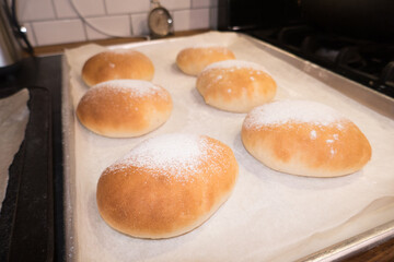 Homemade fresh baked flour bread rolls on a baking sheet
