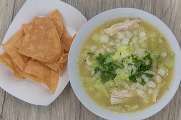 Overhead view of hearty bowl of chicken pozole soup hot from the kitchen and served with a side...