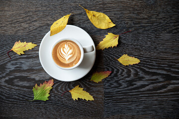 autumn coffee with leaves on a dark background