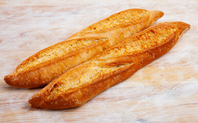 Fresh traditional french baguette bread on wooden table