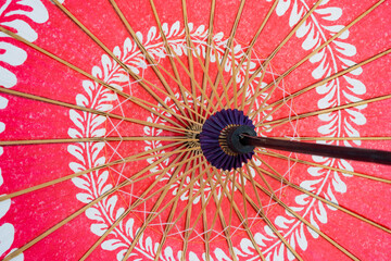 Red japanese umbrella with pattern isolated on white background. Symbol of protection. Traditional and culture design.