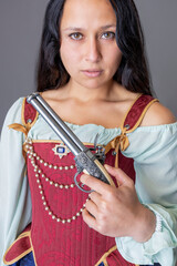 A pirate woman wearing a brocade corset and silk skirt and holding guns