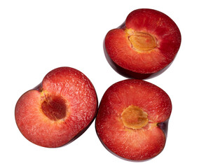 Three halves of a red plum isolated on a white background.Plum slice with a stone on a white background.