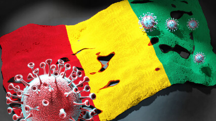 Covid in Guinea - coronavirus attacking a national flag of Guinea as a symbol of a fight and struggle with the virus pandemic in this country, 3d illustration
