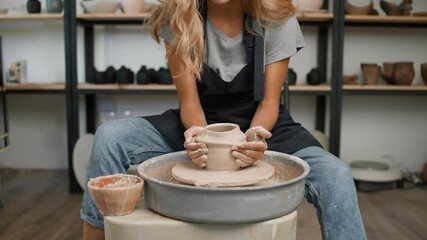 Handcraft, young female potter makes a pitcher out of clay, production of handmade tableware, pottery workshop.