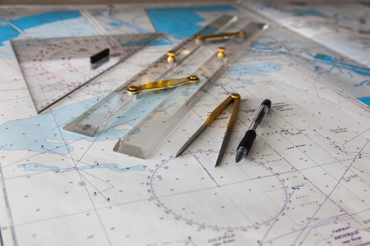 Maps of the ship for plotting. Plotter, divider, ruler and pen. Close-up.