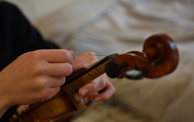 close up of a person changing the violin strings © LemonMyrtle