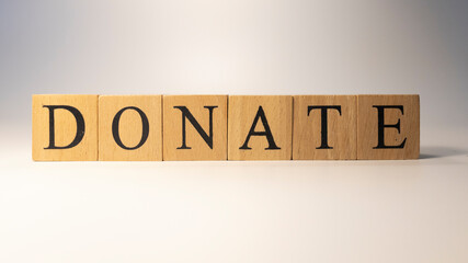 The word Donate was created from wooden cubes.Close-up.