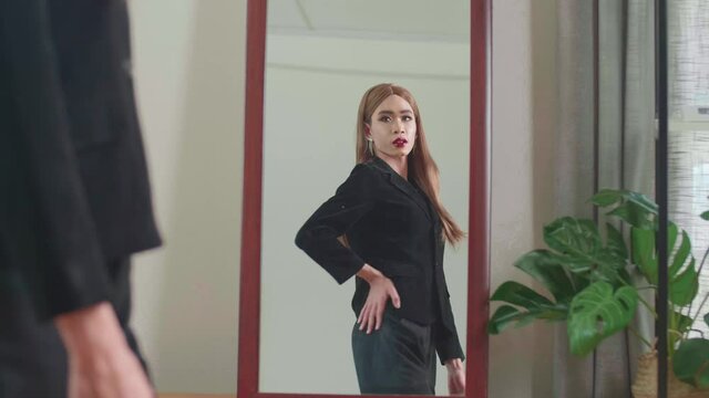Asian Shemale Standing In Front Of Mirror Wearing A Black Cloth
