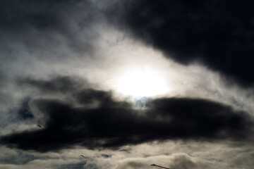 Dark stormy clouds with sun peaking though 