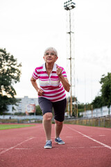 Obraz premium older woman doing gymnastics and running in the stadium, person running