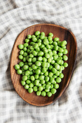 Fresh green peas pods and green peas with sprouts on textile background.