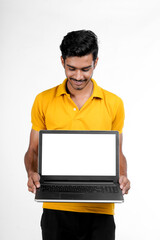 Young indian man showing laptop screen with copy space on white background.