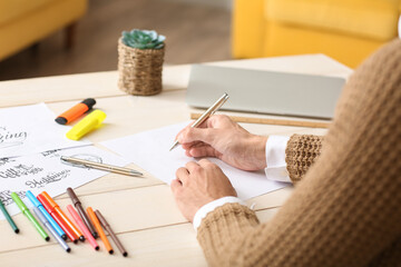 Young male calligrapher working in office, closeup