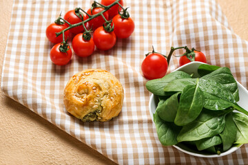 Puff pastry stuffed with spinach and vegetables on color background