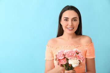 Young woman with beautiful carnation flowers on color background