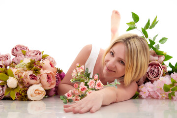 Obraz na płótnie Canvas Pretty skinny girl with beautiful flowers on a white background in photo studio