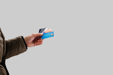 Male hand showing credit cards on gray studio background