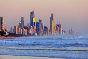 Surfers Paradise cityscape, with surfer going into the ocean