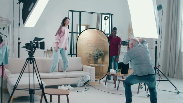 Young lady is jumping on a sofa during professional photoshoot