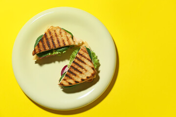 Plate with tasty sandwiches on color background