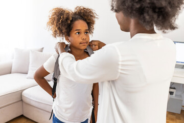 Mother preparing her little girl for the return to school. Back to school concept. Happy family preparing for school. Little girl with mother. Get ready to back to school