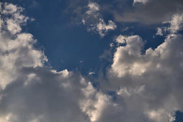 dramatic clouds float across the blue sky