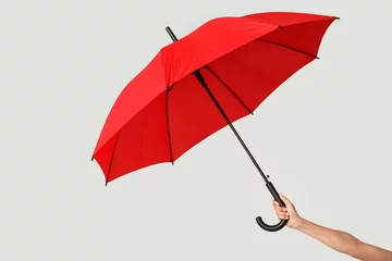 Fotobehang Female hand with open umbrella on light background © Pixel-Shot