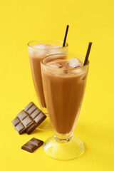 Glasses of tasty chocolate milk on color background