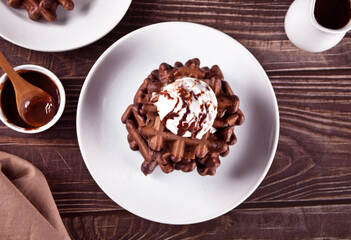 Homemade chocolate waffles with ice cream decorated chocolate syrup.