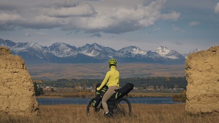 The woman travel on mixed terrain cycle touring with bikepacking. The traveler journey with bicycle...