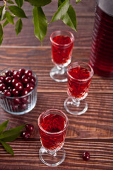glasses of cherry brandy liqueur with ripe berries