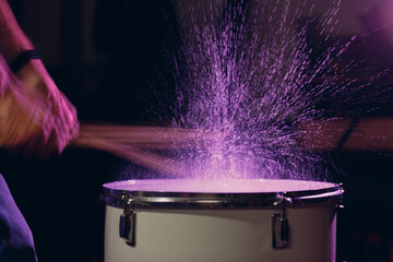 Close up drum sticks drumming hit beat rhythm on drum surface with splash water drops with long...